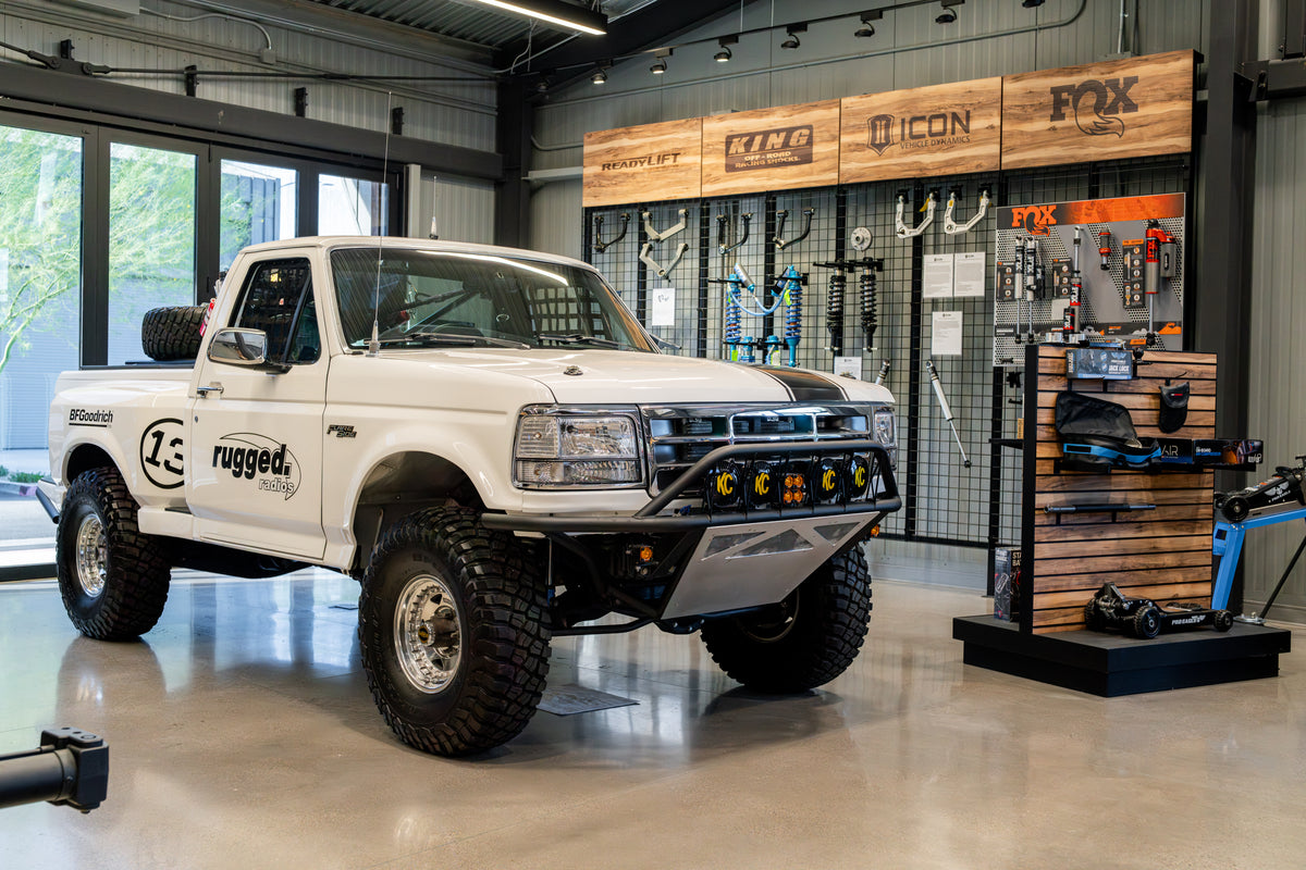 Bronco Barn showroom with a custom truck on display and a wall display showcasing top off-road suspension brands