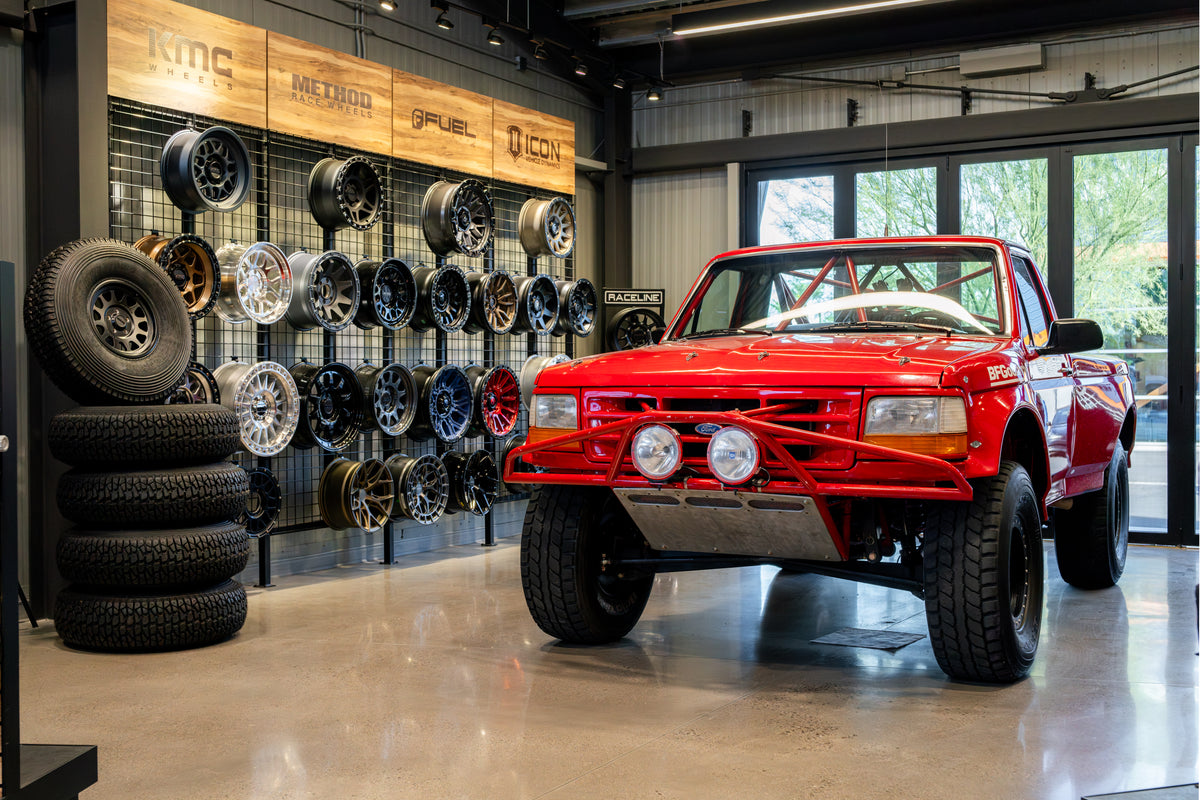 Bronco Barn showroom with a custom Ford on display and showcasing some of the top off-road wheel brands on the wall